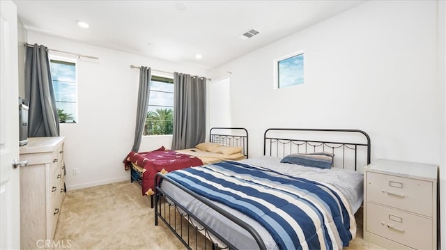 bedroom featuring light carpet and multiple windows