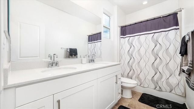 bathroom featuring double sink, tile floors, large vanity, and toilet