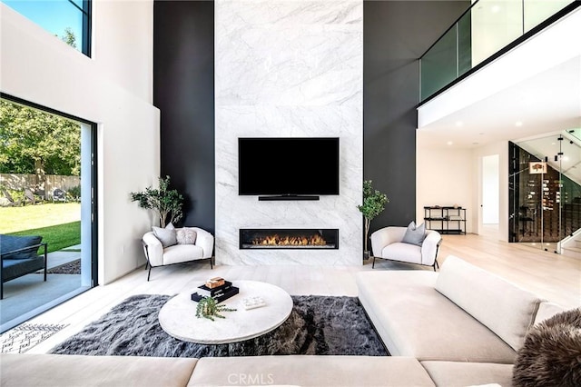 living room featuring a fireplace, a towering ceiling, and plenty of natural light