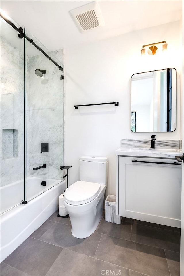 full bathroom featuring vanity, bath / shower combo with glass door, and toilet