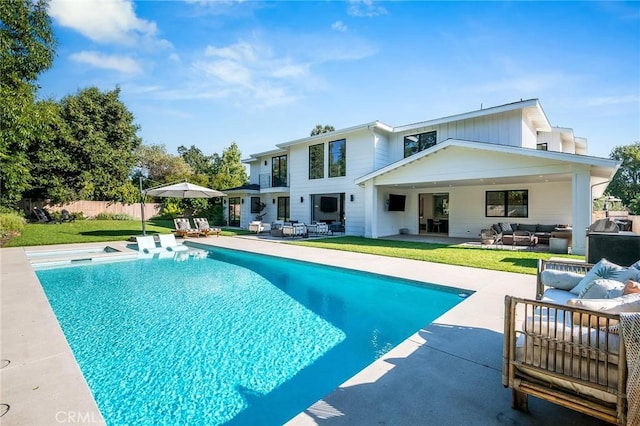 back of property featuring a fenced in pool, an outdoor hangout area, a patio, and a yard