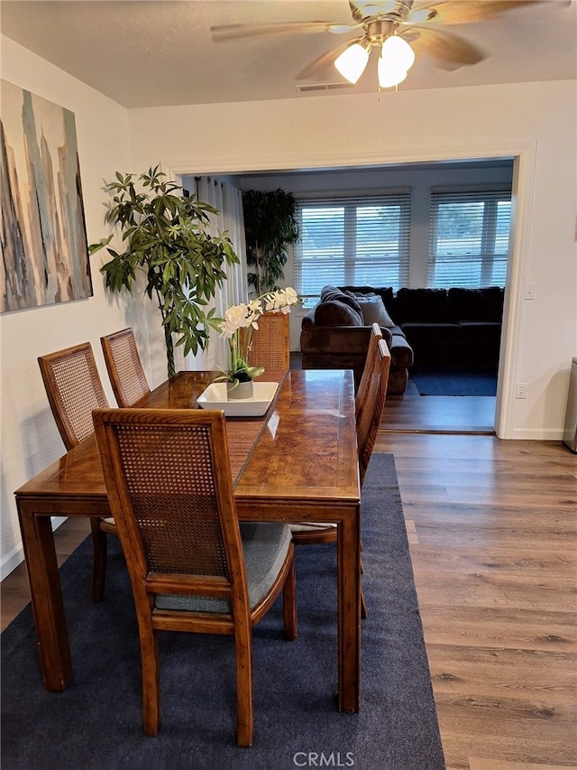 dining space with wood-type flooring and ceiling fan