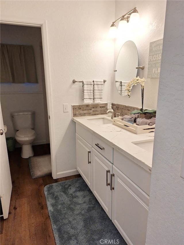 bathroom featuring vanity, hardwood / wood-style flooring, and toilet