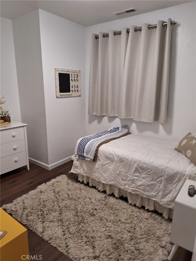 bedroom with dark wood-type flooring