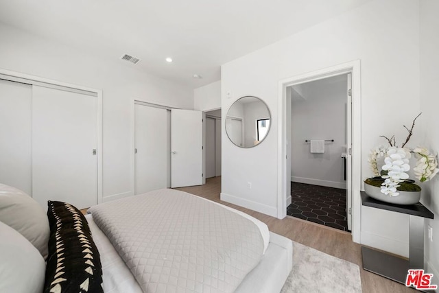 bedroom featuring light hardwood / wood-style floors and connected bathroom