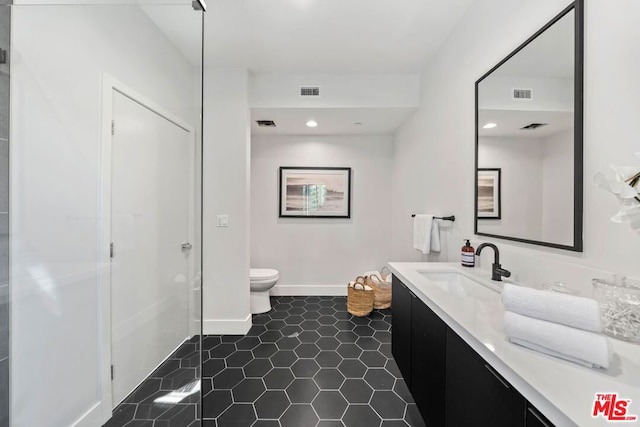 bathroom with tile patterned flooring, vanity, and toilet