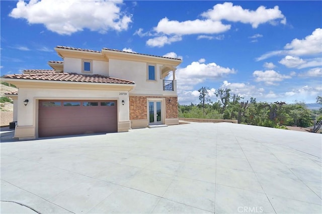 mediterranean / spanish-style home featuring a balcony and a garage