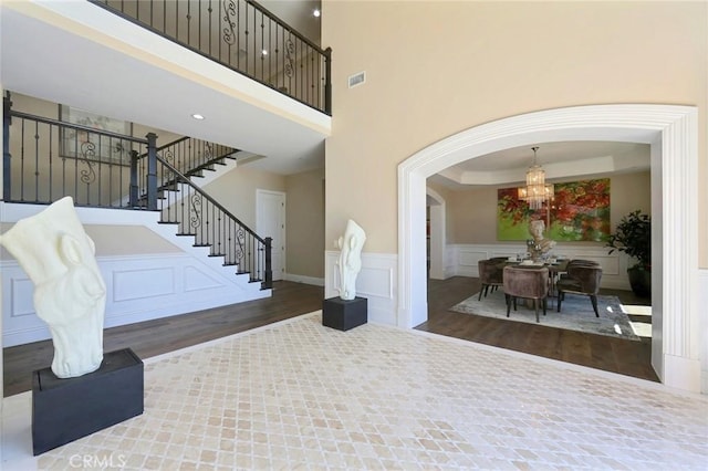 entryway featuring dark hardwood / wood-style flooring, a chandelier, and a high ceiling