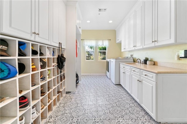 laundry area with washer and dryer, sink, light tile patterned flooring, and cabinets