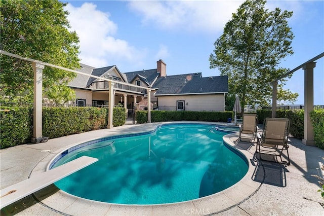 view of pool featuring a patio and a diving board