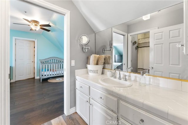 bathroom with ceiling fan, vanity, wood-type flooring, and lofted ceiling