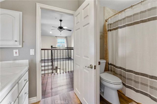 bathroom with hardwood / wood-style flooring, ceiling fan, toilet, and vanity