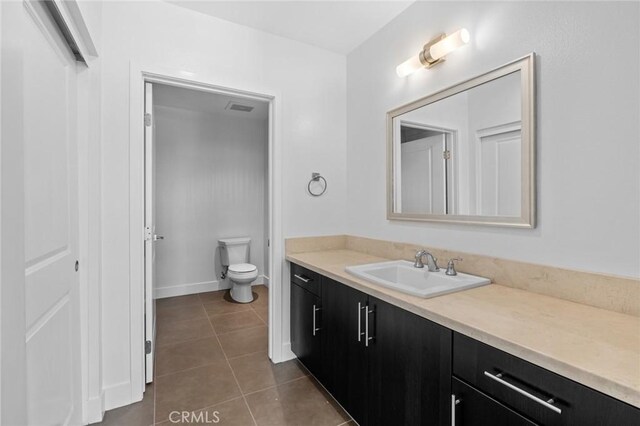 bathroom featuring tile patterned flooring, vanity, and toilet