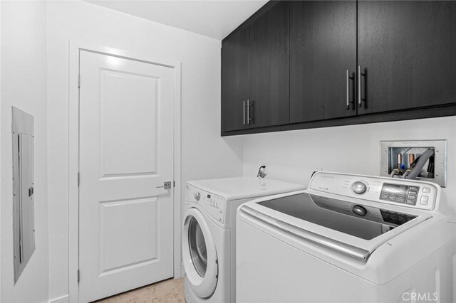 laundry area featuring electric panel, cabinets, light tile patterned floors, and washing machine and dryer