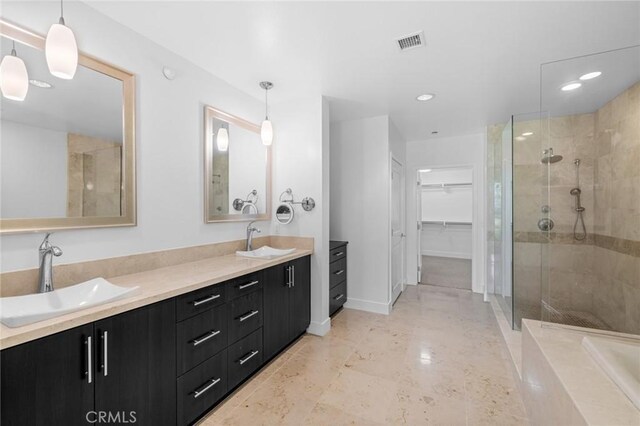 bathroom with vanity and a tile shower