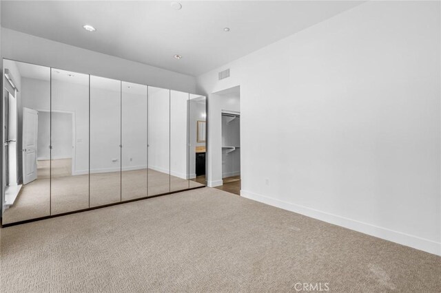 unfurnished bedroom with carpet flooring and a closet