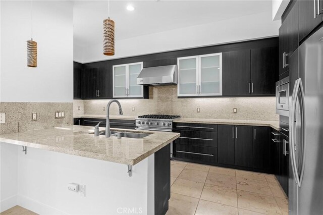 kitchen with wall chimney exhaust hood, backsplash, kitchen peninsula, decorative light fixtures, and appliances with stainless steel finishes