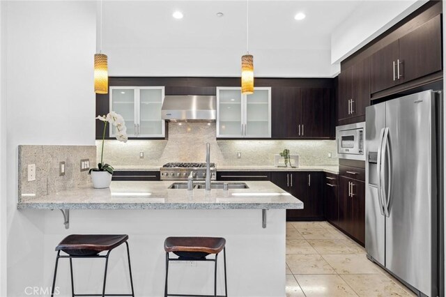 kitchen with tasteful backsplash, kitchen peninsula, wall chimney exhaust hood, and stainless steel appliances