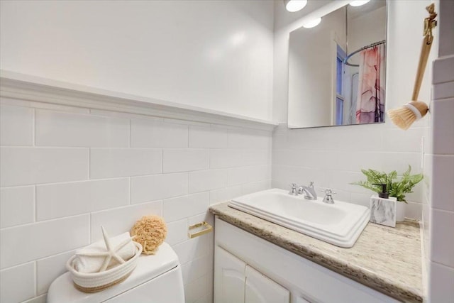 bathroom with toilet, tile walls, vanity, and curtained shower