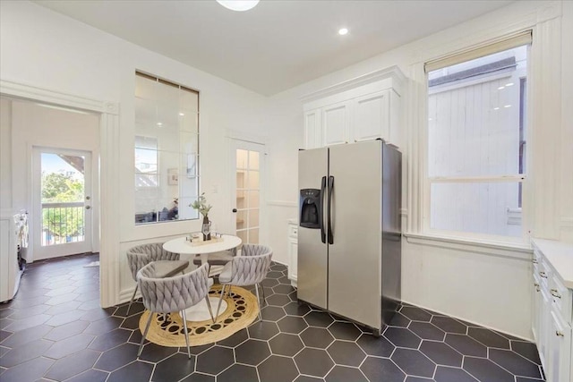 kitchen with white cabinets, stainless steel fridge, and washing machine and clothes dryer