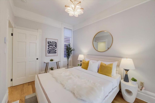 bedroom with an inviting chandelier and wood-type flooring