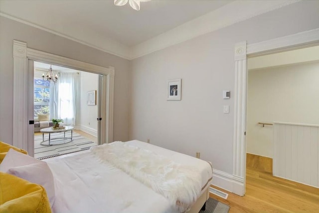 bedroom with an inviting chandelier and light hardwood / wood-style flooring