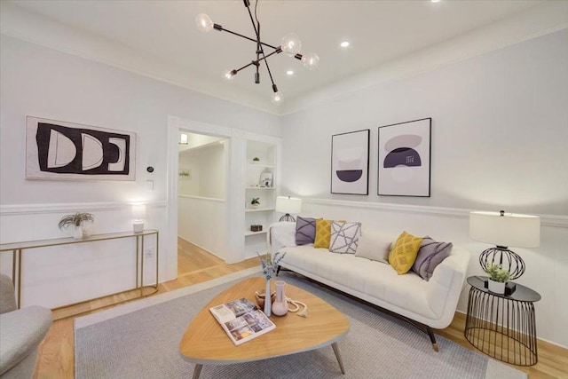 living room featuring light wood-type flooring, built in features, and a notable chandelier