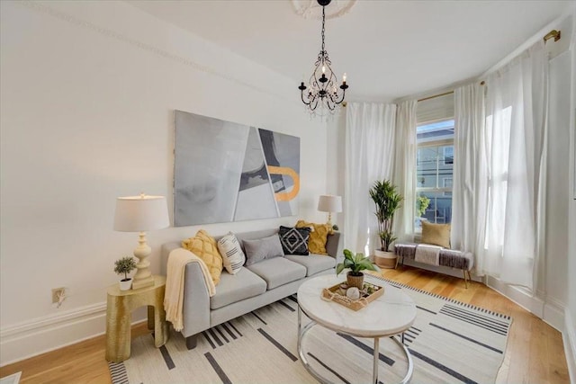 living room with light hardwood / wood-style floors and a notable chandelier