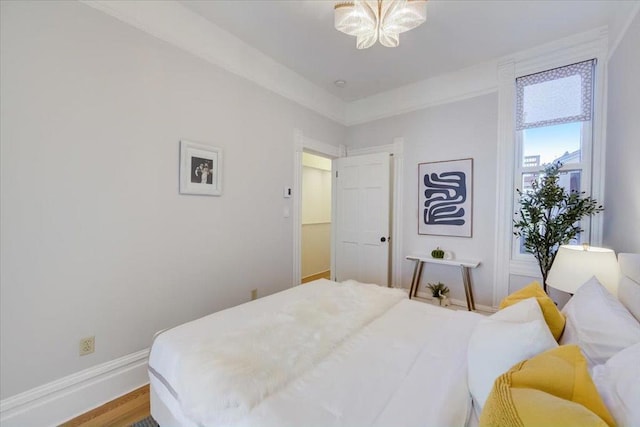 bedroom featuring wood-type flooring and a notable chandelier