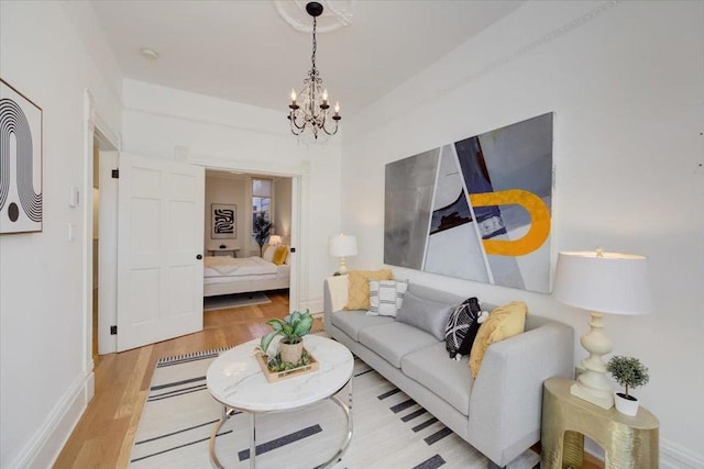 living room with light hardwood / wood-style floors and an inviting chandelier