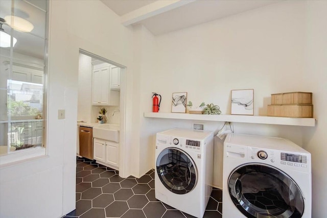 laundry room featuring dark tile patterned flooring, washing machine and clothes dryer, and sink