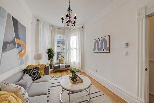 living room with light wood-type flooring and an inviting chandelier