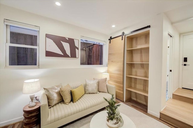 living room featuring a barn door and hardwood / wood-style flooring