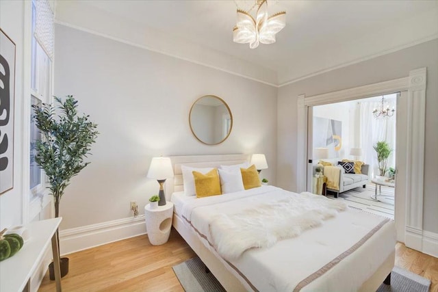 bedroom with wood-type flooring and an inviting chandelier