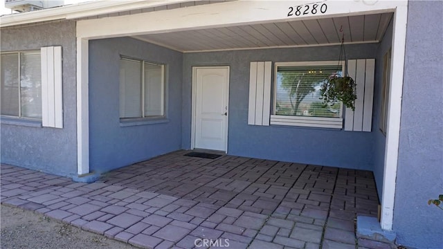 view of exterior entry featuring a patio