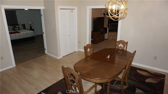 dining area with a notable chandelier and light hardwood / wood-style floors