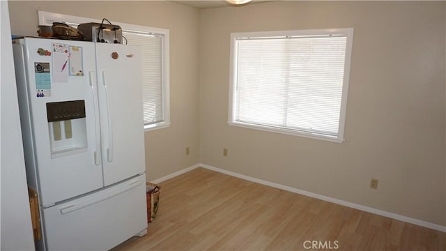 kitchen with white refrigerator with ice dispenser and light hardwood / wood-style flooring