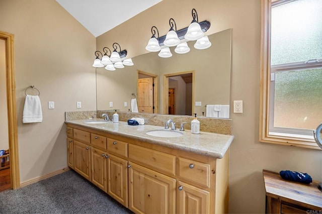 bathroom featuring double vanity and vaulted ceiling