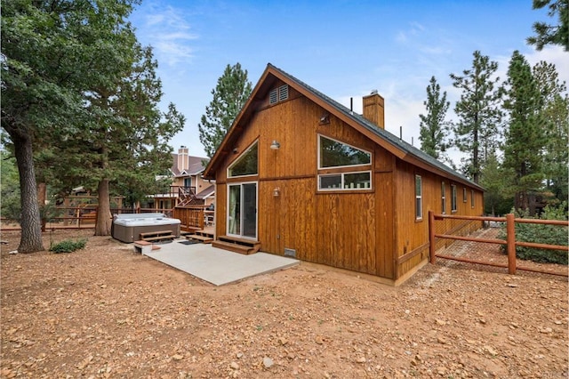 rear view of house featuring a patio area and a hot tub