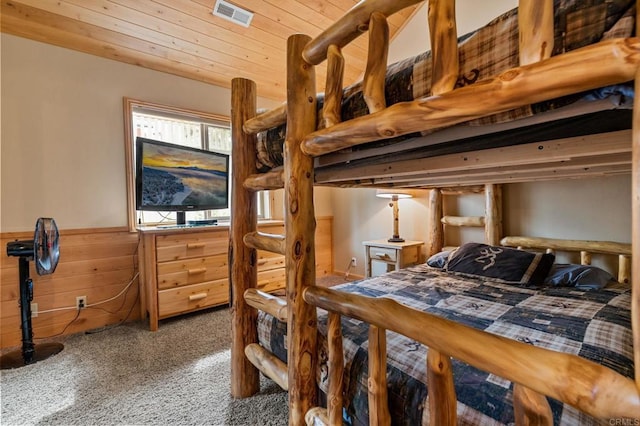 bedroom featuring wood walls, carpet, and wooden ceiling