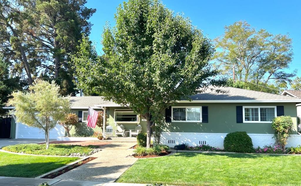 single story home featuring a front lawn and a garage