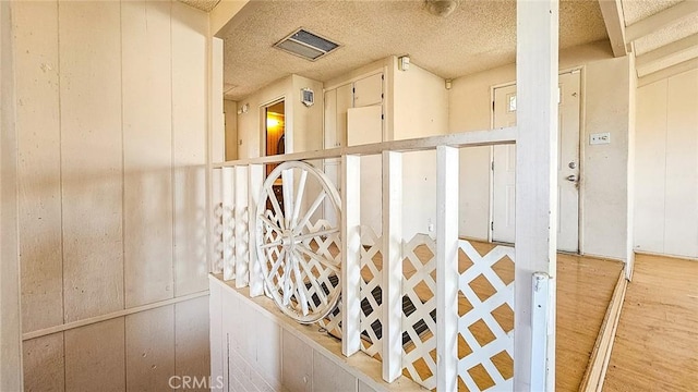 room details featuring wood walls and a textured ceiling