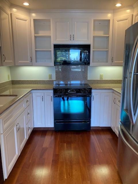 kitchen with black appliances, white cabinets, light stone countertops, and dark wood-type flooring