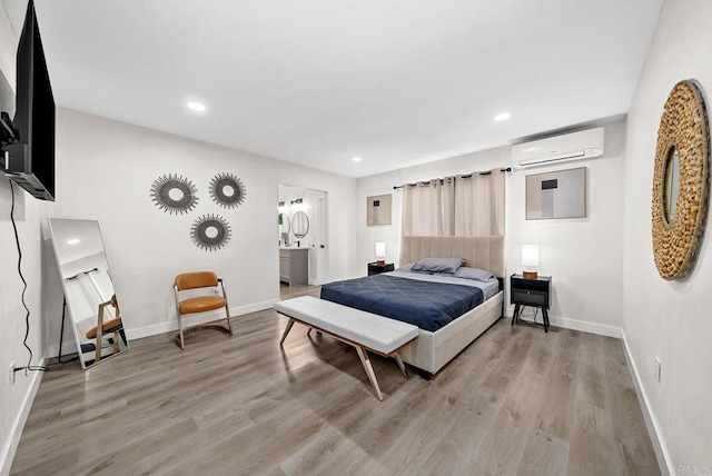 bedroom featuring a wall mounted AC and light hardwood / wood-style floors