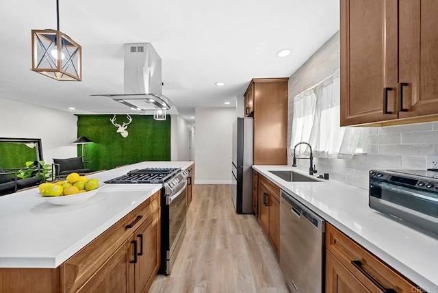 kitchen with sink, light wood-type flooring, stainless steel appliances, island exhaust hood, and pendant lighting