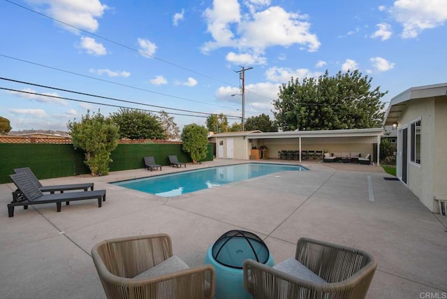 view of pool with a lawn and a patio