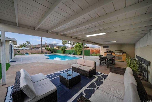 view of terrace with a grill, an outdoor bar, an outdoor living space, and a fenced in pool