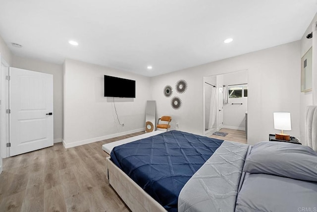 bedroom featuring light hardwood / wood-style flooring and connected bathroom