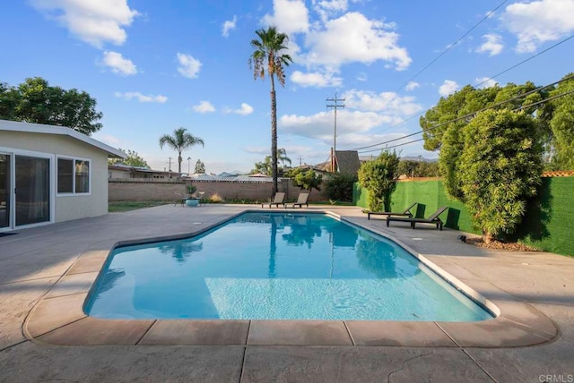 view of pool with a patio and a yard