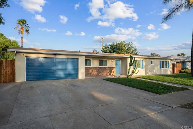 ranch-style home featuring a front lawn and a garage